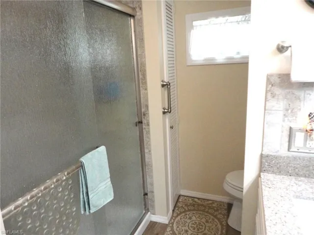 Guest Bathroom with a shower with door and toilet