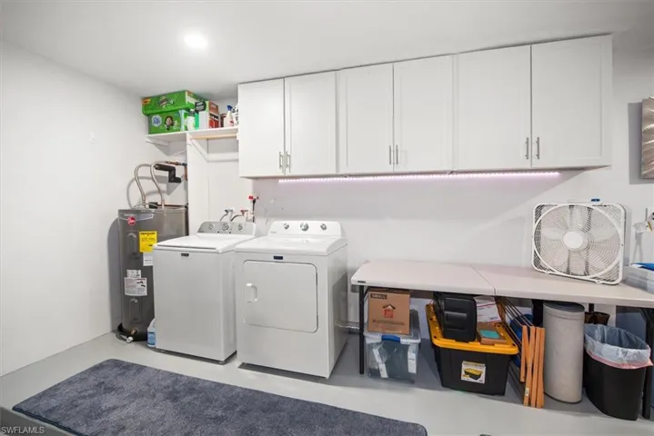 Laundry area featuring a top-load washer, front-load dryer, and overhead cabinetry