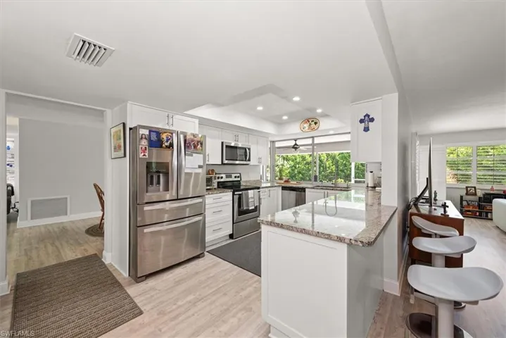 Kitchen featuring white cabinetry, stainless steel appliances, and granite countertops