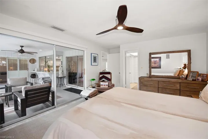 Spacious interior featuring a wood-finish ceiling fan, neutral wall tones, and carpet flooring