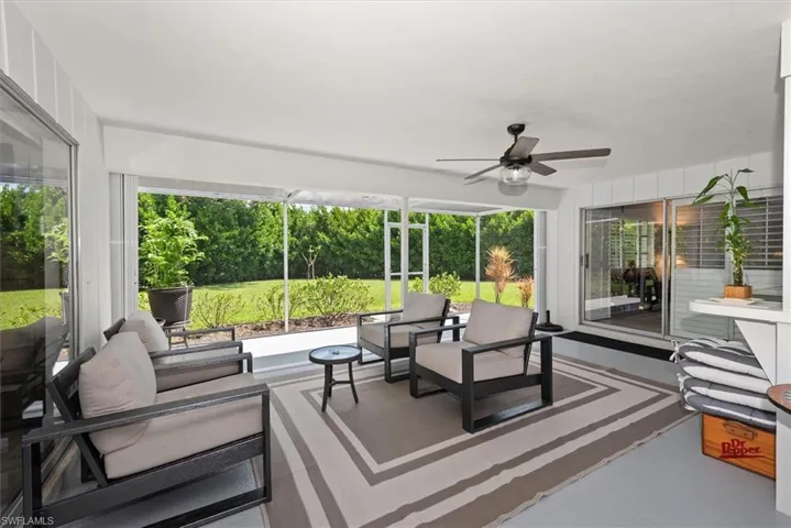Screened patio with painted concrete flooring and a ceiling fan