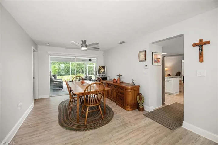 Dining area featuring wood-finish flooring, light grey walls, and a ceiling fan