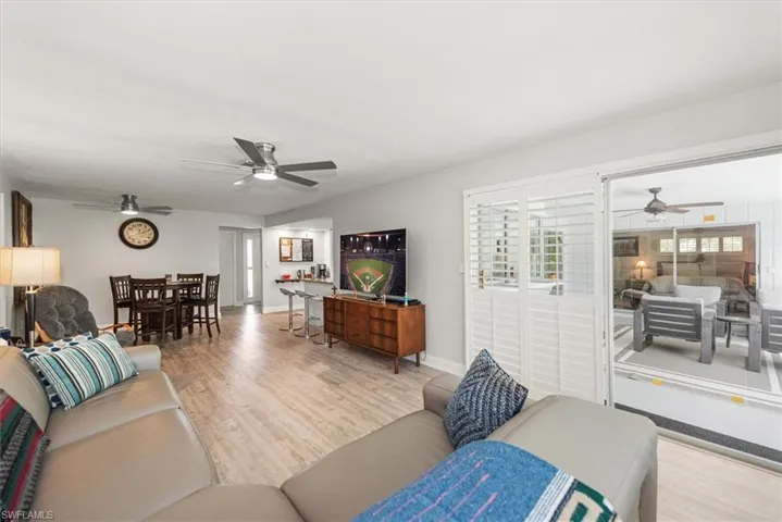 Open-concept living space featuring wood-finish flooring, recessed lighting, and multiple ceiling fans