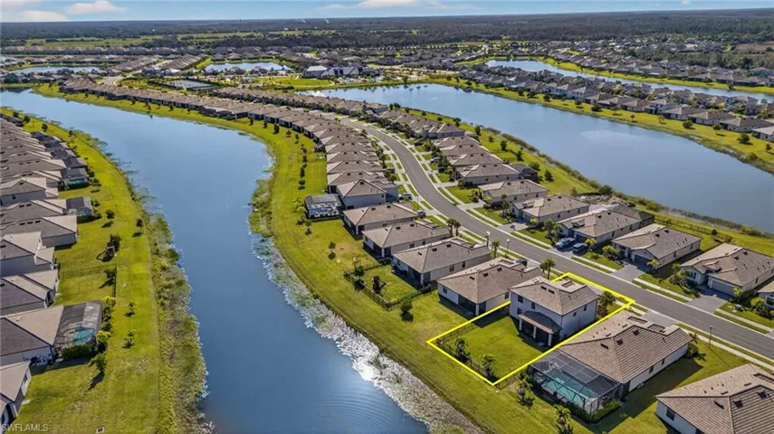 Aerial view of residential area featuring a large body of water and property parcel outlined
