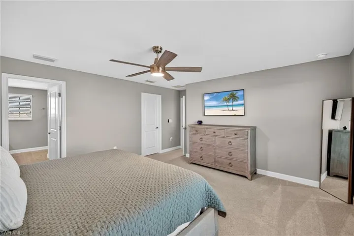 Bedroom with light colored carpet and ceiling fan