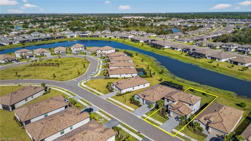 Aerial perspective of suburban area featuring a nearby body of water and property parcel outlined