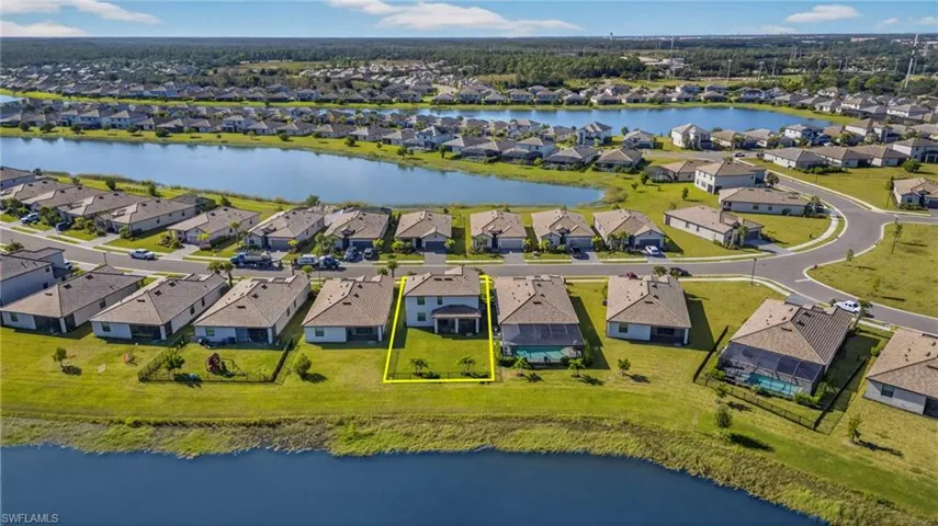Aerial view of residential area with a large body of water and property parcel outlined