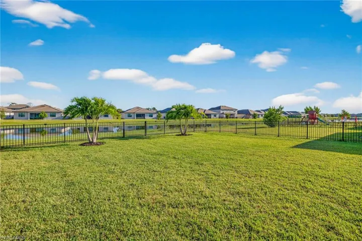 Fenced backyard featuring a residential view, a water view, and a playground