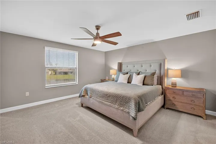Carpeted bedroom with baseboards and a ceiling fan