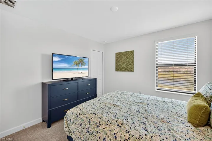 Bedroom featuring light colored carpet and baseboards