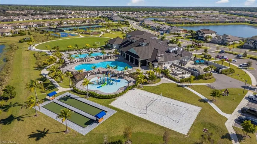 Aerial perspective of suburban area featuring a pool area and a large body of water