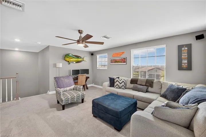 Living room with a ceiling fan and carpet
