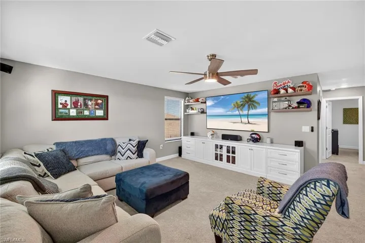 Living room with light colored carpet and a ceiling fan