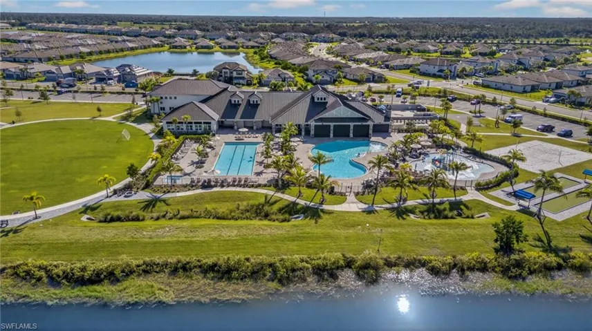 Aerial view of residential area with a nearby body of water and a pool