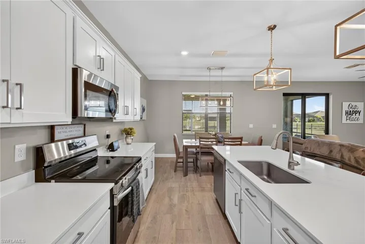 Kitchen with appliances with stainless steel finishes, light wood-style floors, white cabinets, and recessed lighting