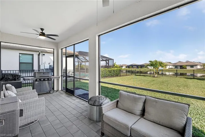 Sunroom with an outdoor living space, ceiling fan, and a residential view