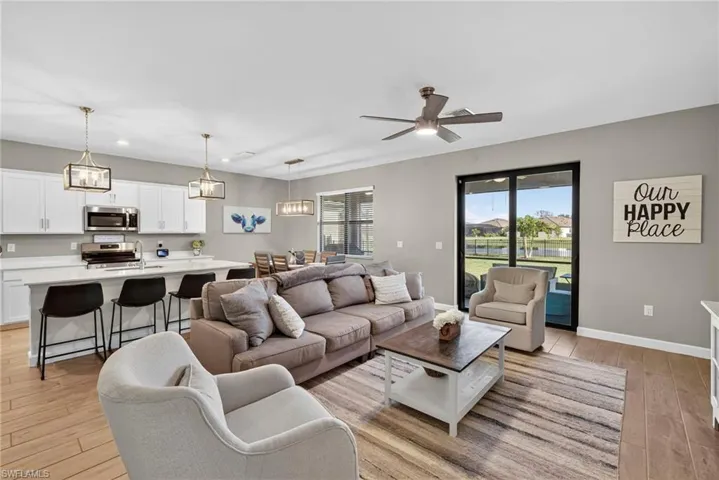 Living area featuring light wood-style flooring, a ceiling fan, a water view, and recessed lighting