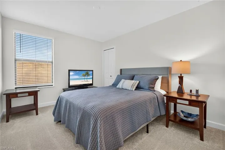 Bedroom featuring light carpet and a closet