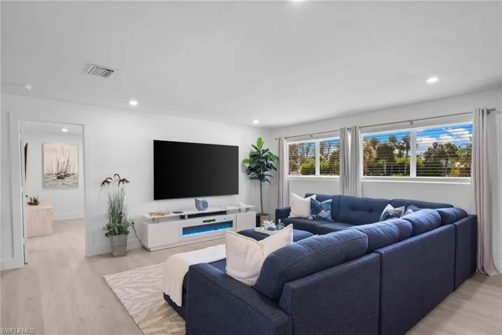 Neutral-toned interior featuring wood-finish flooring, recessed lighting, and horizontal windows with natural light exposure