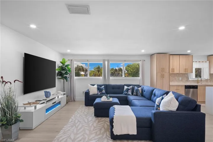 Open-concept living space featuring wood-finish flooring, recessed lighting, and expansive windows