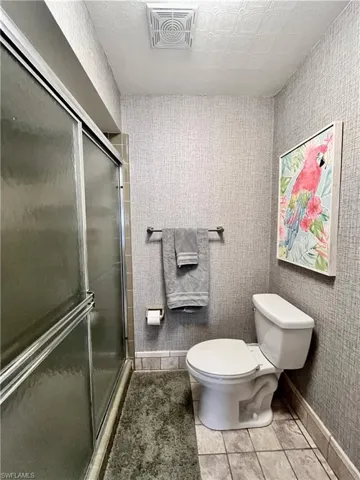 Full bathroom with light tile patterned flooring and a shower stall