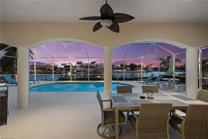 Swimming pool featuring a patio area, a lanai, and a water view