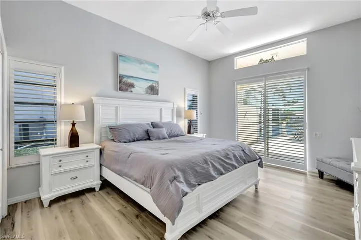 Primary Bedroom featuring a ceiling fan, access to pool area, and light wood-type flooring