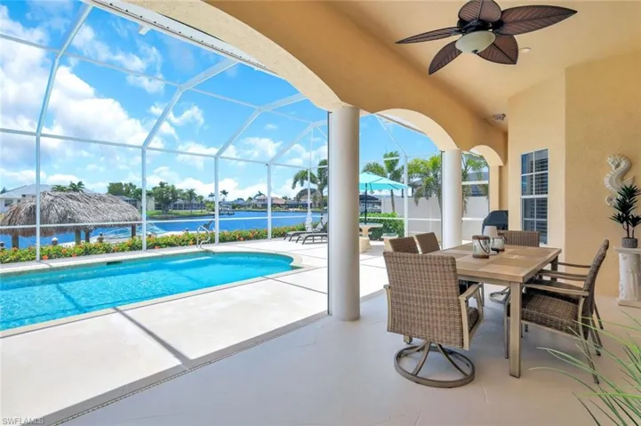 Pool featuring a patio, outdoor covered dining area, a ceiling fan, view of canal, and Screen enclosure