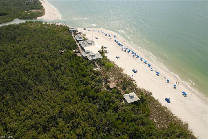 Enjoy Pelican Bay beach service with chairs and umbrellas