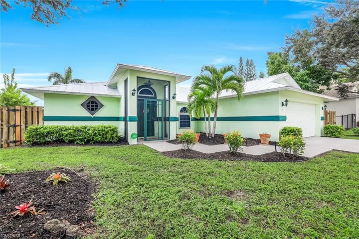 Ranch-style home with a metal roof, stucco siding, a garage, and driveway