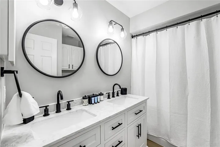 Full bathroom with double vanity and a shower with curtain