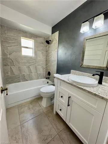 Full bathroom with shower / washtub combination, vanity, and light tile patterned flooring