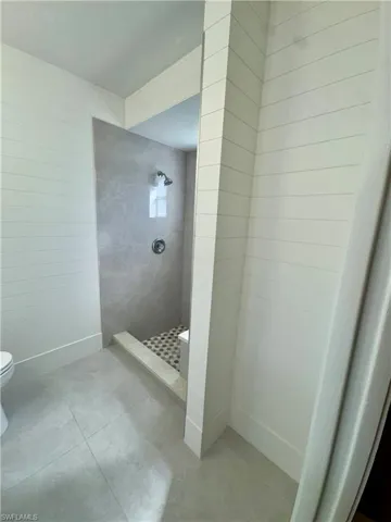 Full bath featuring a walk in shower and light tile patterned flooring