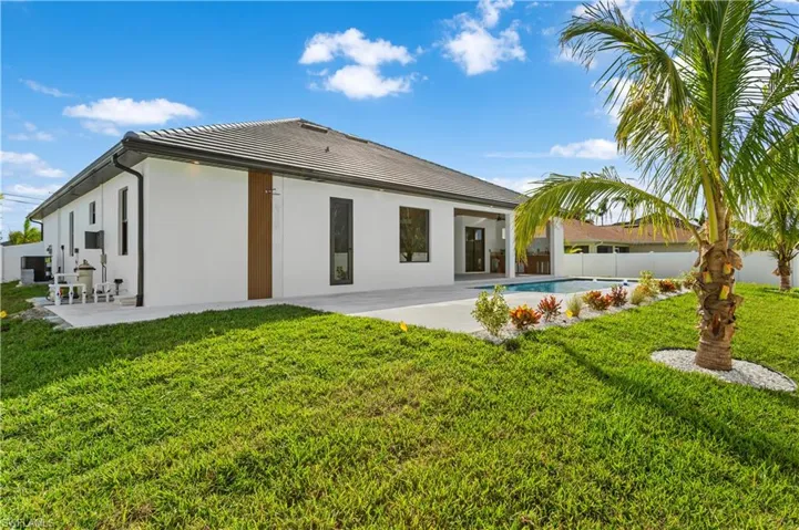 A spacious backyard with lush landscaping, featuring an outdoor half bathroom and a shower/ducha, keeping the indoors mess-free!