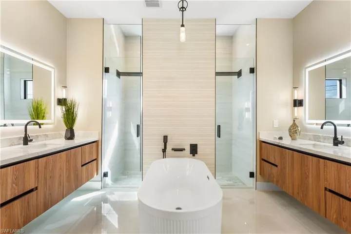 Enjoy DUO SHOWER w/ HAND-HELD SHOWER HEADS, LUXURIOUS FREESTANDING TUB, CUSTOM VANITIES w/ QUARTZ COUNTERTOPS & ELECTRIC TOILET w/ BIDET FUNCTION for ULTIMATE RELAXATION.