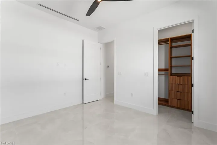 SPACIOUS GUEST BEDROOM 3 with custom built cabinets in closet.