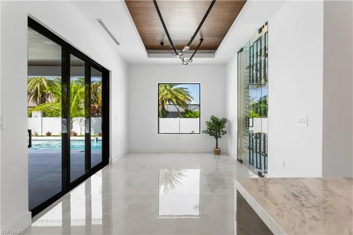 Formal DINING ROOM offers AMPLE SPACE for hosting guests, w/ STACKABLE DOORS to LANAI & LARGE PICTURE WINDOW overlooking POOL.