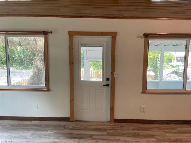Doorway featuring wood finished floors and wood ceiling
