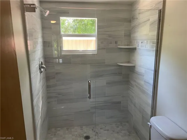Bathroom featuring a stall shower and toilet