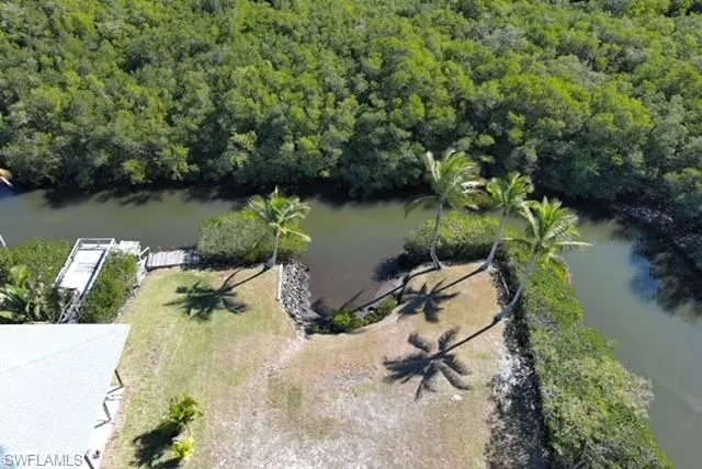 Aerial view of property's location with a large body of water and a heavily wooded area