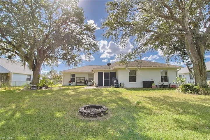 Expansive green lawn with mature trees providing natural shade