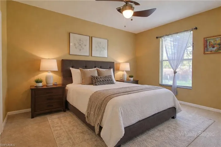 Carpeted room featuring a ceiling fan with integrated lighting, a window with blinds, and a built-in wall light fixture
