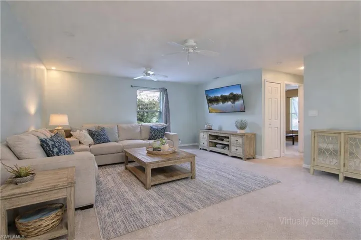 Carpeted living area featuring recessed lighting, a window with exterior views, and a ceiling fan