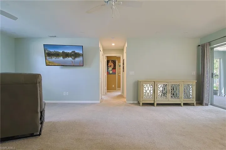 Carpeted interior space with a ceiling fan