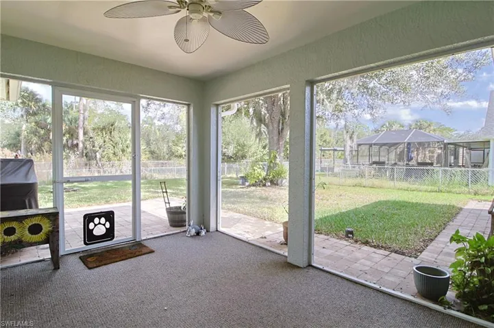 Screened-in patio with light-toned carpet flooring and a ceiling fan