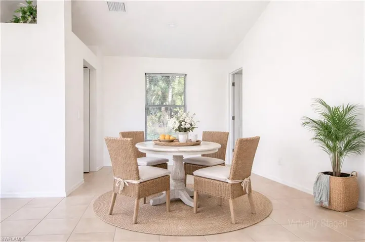 Light-filled dining area featuring tile flooring, white walls, and a window with horizontal blinds