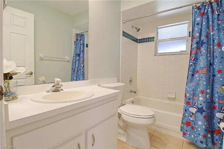 Bathroom featuring a vanity with integrated sink, a rectangular mirror, and a toilet
