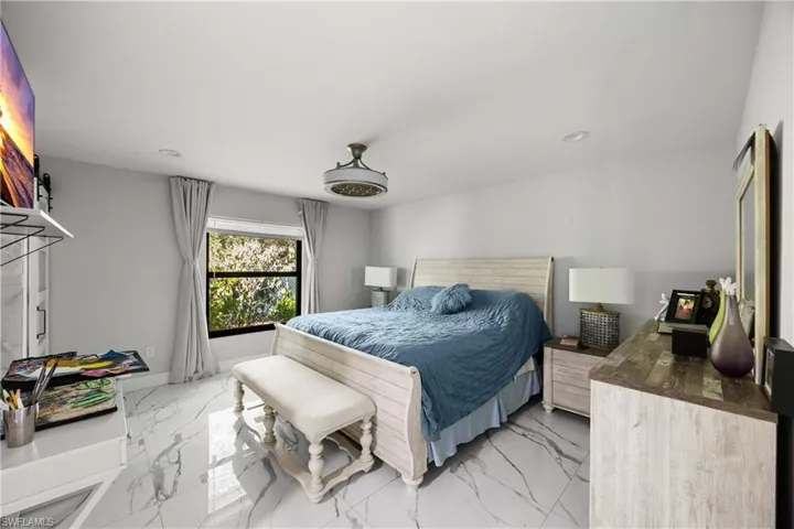 Bedroom featuring light marble finish floors and recessed lighting