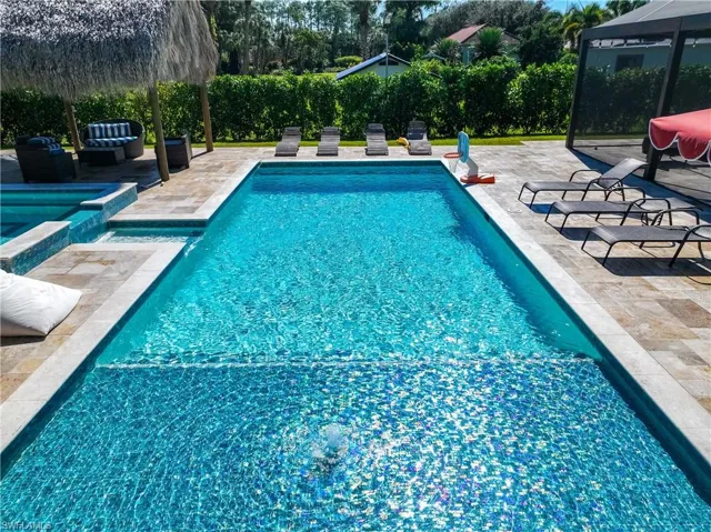 View of swimming pool featuring a patio area and a pool with connected hot tub