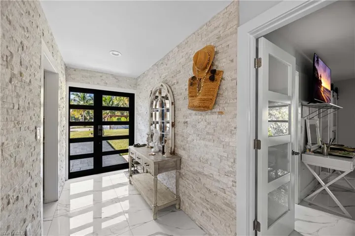 Doorway to outside with french doors and marble finish floors